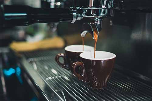 Two cups with espresso being poured into them. This image sits at the top of Bean Merchants blog on getting the perfect espresso extraction